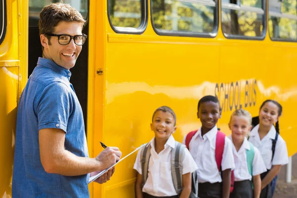 Smiling teacher updating check list of kids