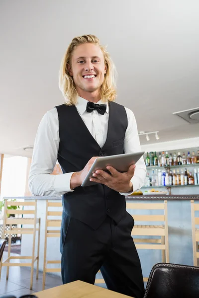 Waiter using digital tablet in restaurant