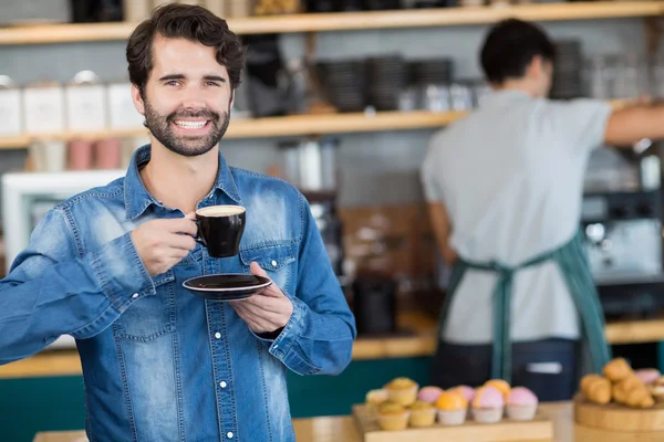 Portrait of happy man having cup of coffee in cafe