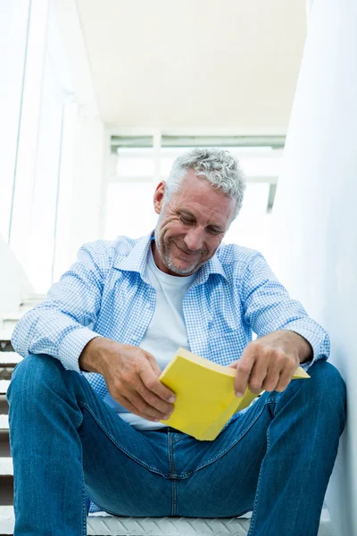 Smiling man reading book