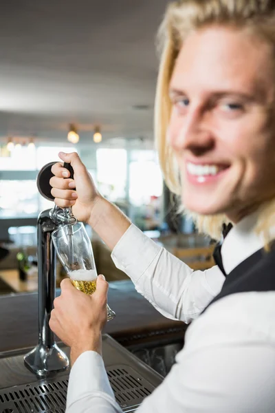 Waiter filling beer from bar pump