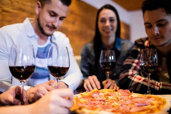 Friends enjoying pizza and wine