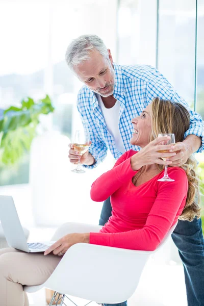 Man giving wineglass to woman