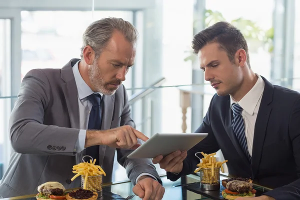 Businessmen using digital tablet in restaurant