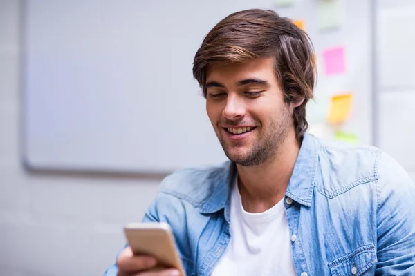 Smiling man using mobile phone