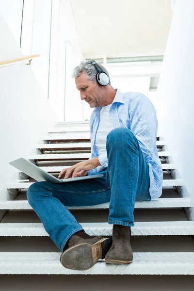 Man using laptop on steps