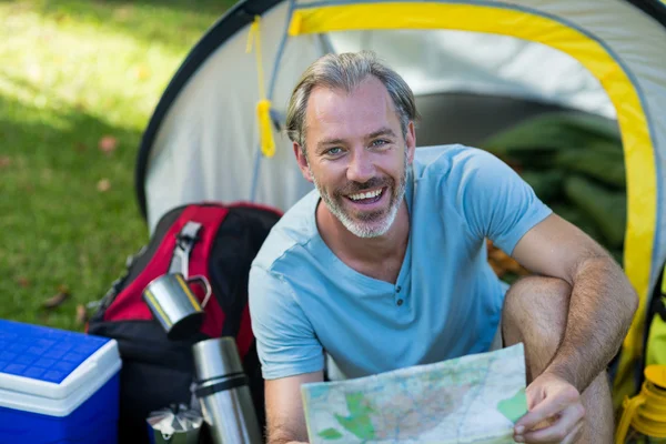 Portrait of happy hiker holding map