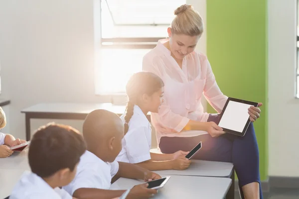 Teacher teaching kids on digital tablet