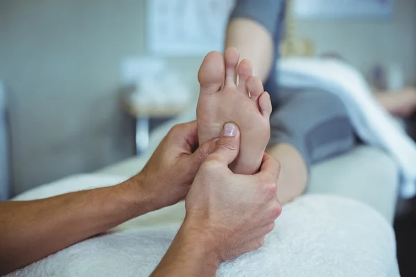 Physiotherapist giving foot massage to a woman