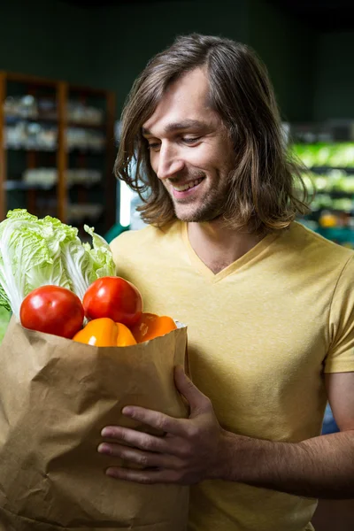 Man holding bag of vegetables