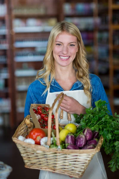 Female staff holding basket of vegetables