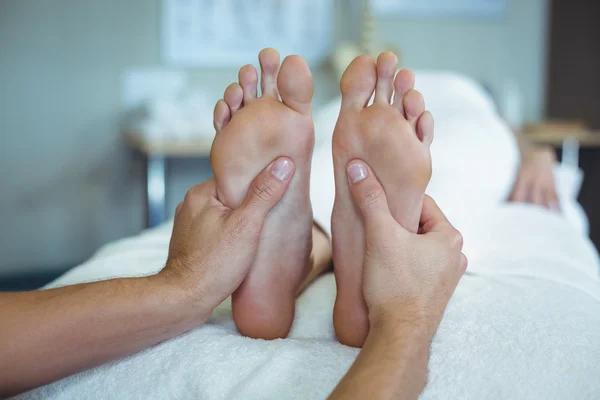 Physiotherapist giving foot massage to a woman