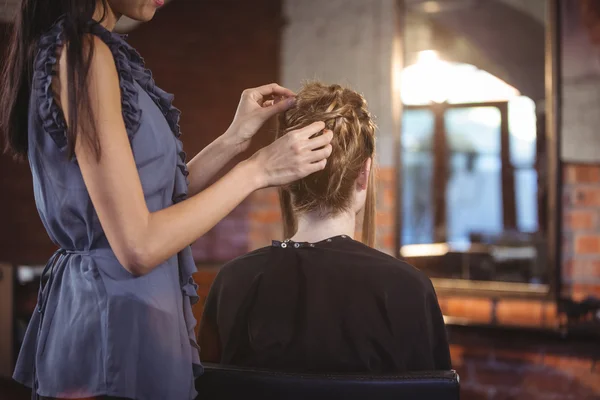 Female hairdresser styling customers hair