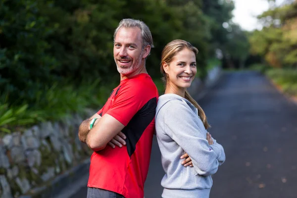 Athletic couple standing back to back