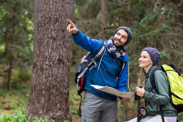 Hiker couple looking at map and pointing away