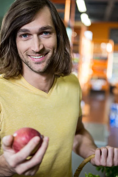 Man holding apple in supermarket