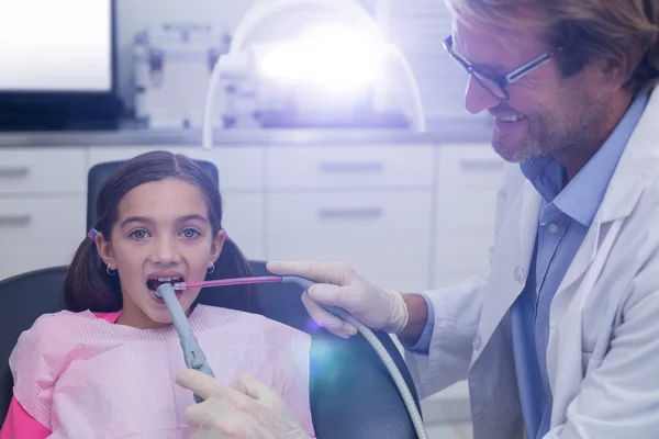 Dentist examining a young patient with tools