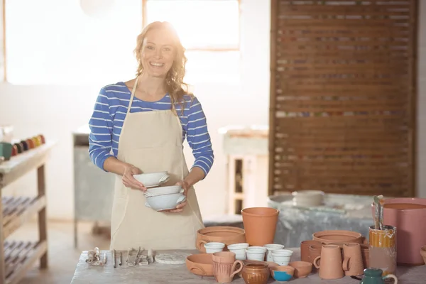 Beautiful female potter holding bowl