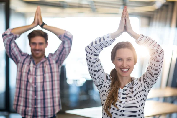 Business people performing yoga in office