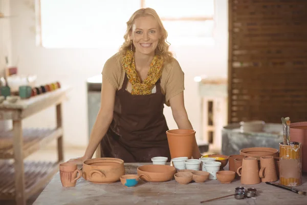 Female potter leaning on worktop