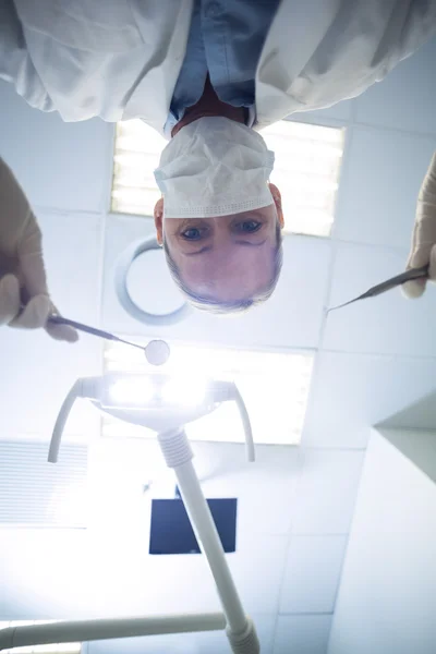 Female dentist holding dental tools