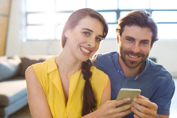 Female business executive showing mobile phone to co-worker