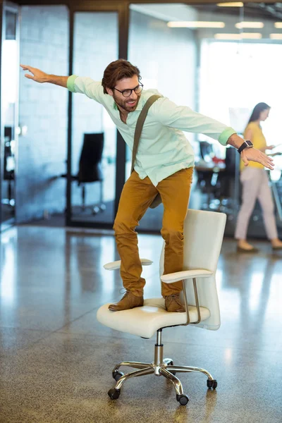 Male business executive standing on chair
