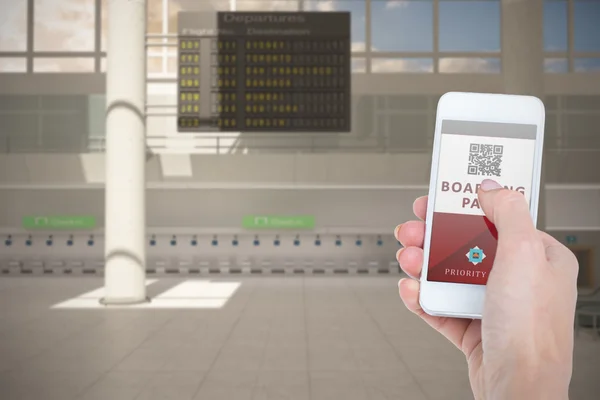 Hand holding smartphone with boarding pass