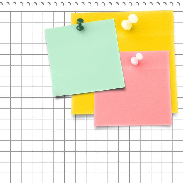 Sticky notes with thumbtacks against notepad