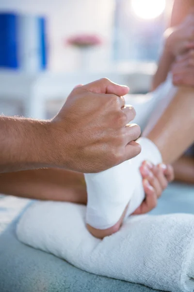 Physiotherapist giving foot massage to a woman