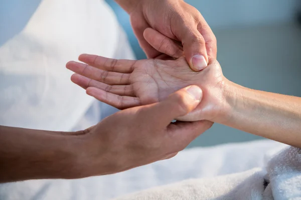 Physiotherapist giving hand massage to a woman