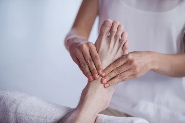 Physiotherapist giving foot massage to a patient