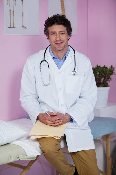 Portrait of physiotherapist sitting on examination bed