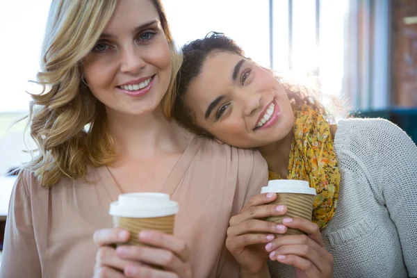 Portrait of female friends sitting together and having coffee