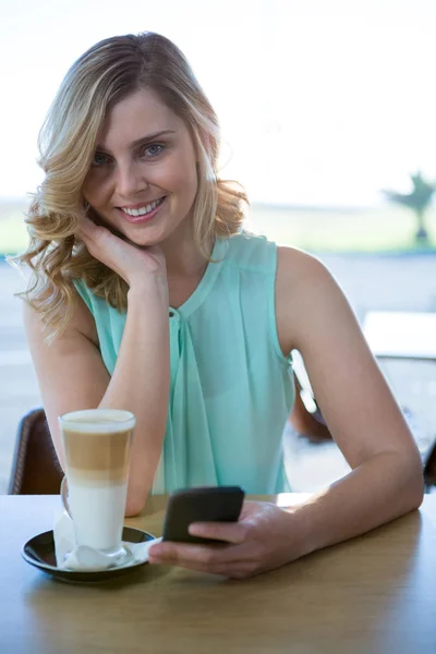 Woman using her mobile phone in the coffee shop