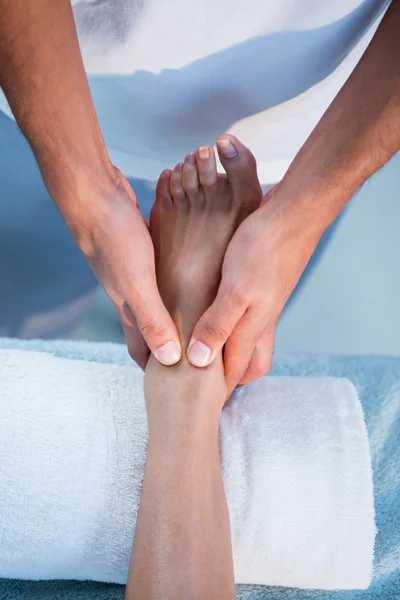 Physiotherapist giving foot massage to a woman