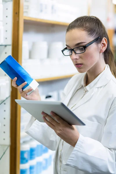 Pharmacist using tablet while checking medicine