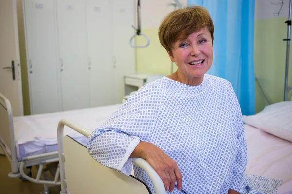 Smiling senior patient sitting on a bed