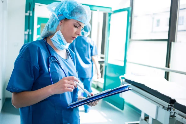 Female surgeon looking at clipboard