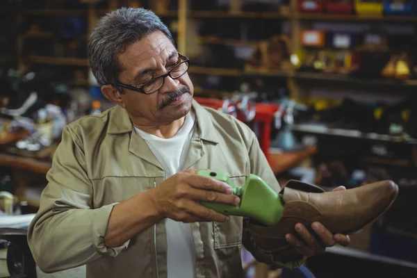 Shoemaker repairing a shoe sole