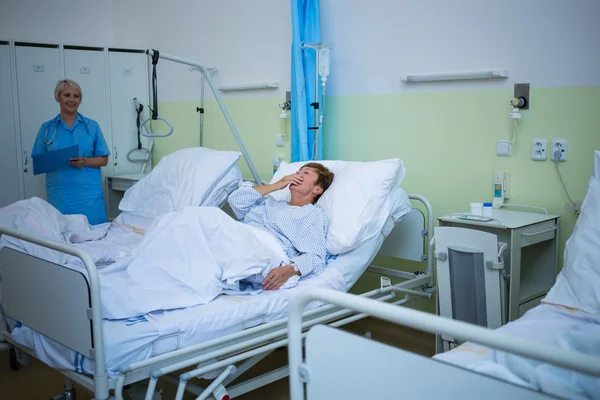 Senior patient laughing while lying on a bed