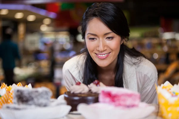 Woman selecting desserts from display