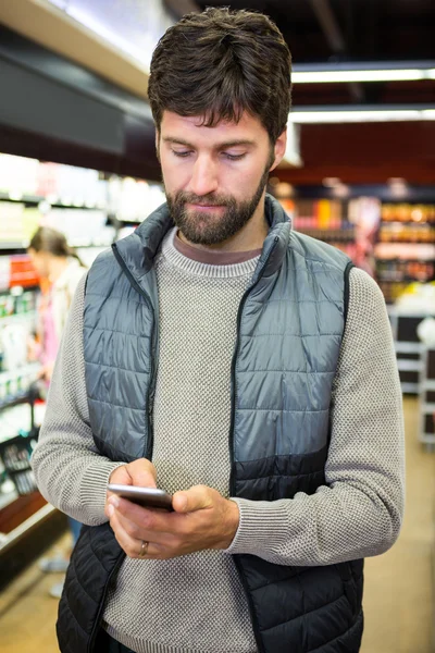 Man using phone in grocery section