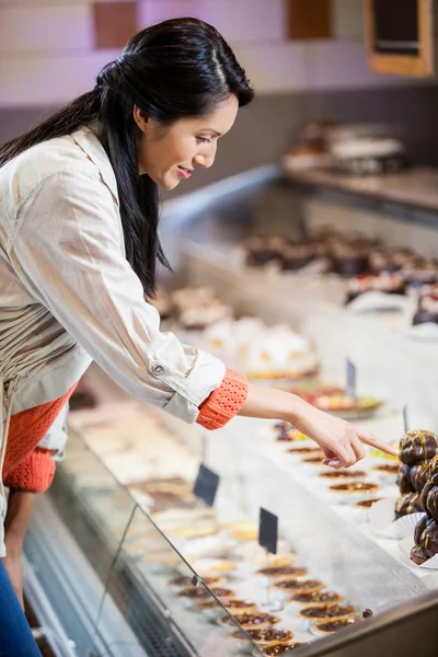 Happy woman selecting desserts