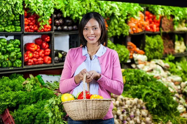Woman holding fruits and vegetables in basket