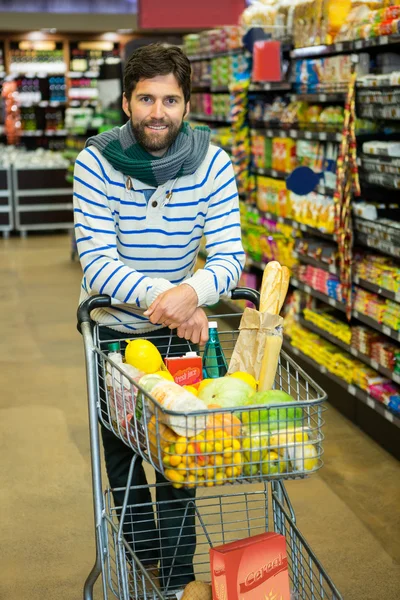 Man with trolley in grocery section