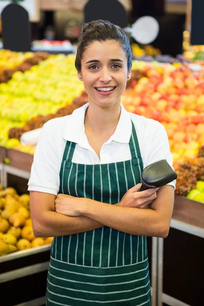 Female staff standing with arms crossed in supermarket