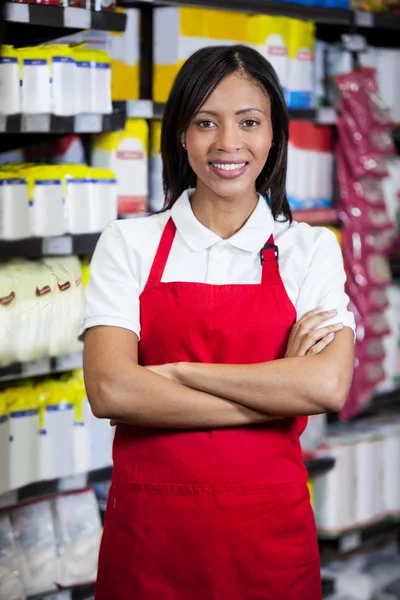 Female staff with arms crossed in supermarket