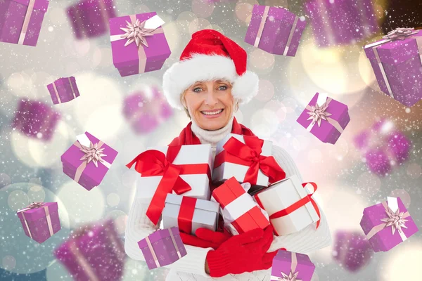 Composite image of festive woman holding gifts