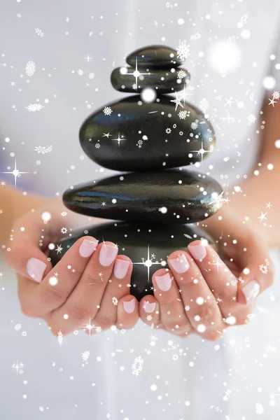 Beauty therapist holding pile of stones